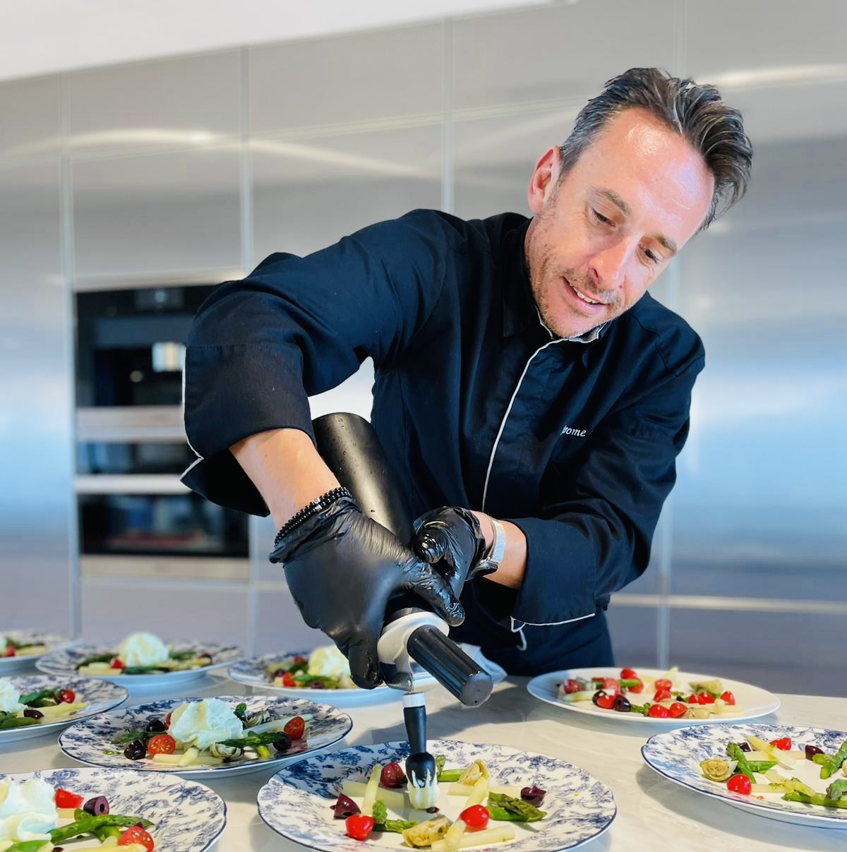 Chef Jérôme Abraham finishing appetizers at the kitchen counter